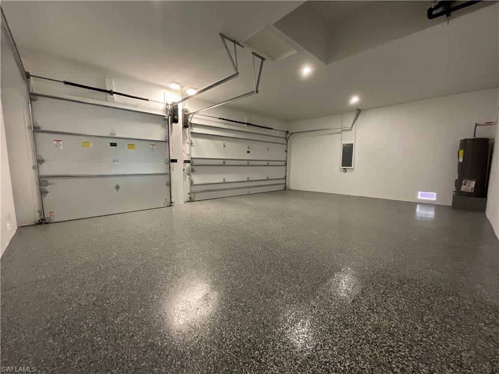 Spacious garage with an epoxy finished floor, two garage doors, and overhead lighting