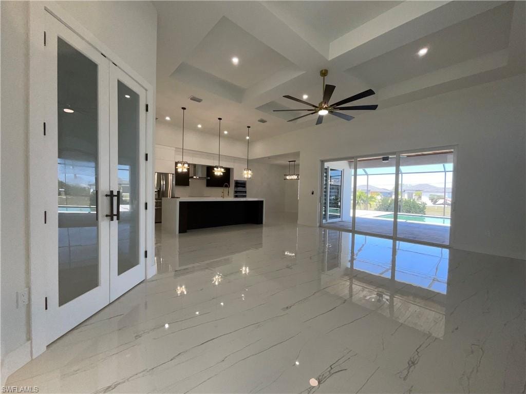 Expansive living area with large format tile flooring, a modern ceiling fan, and recessed lighting