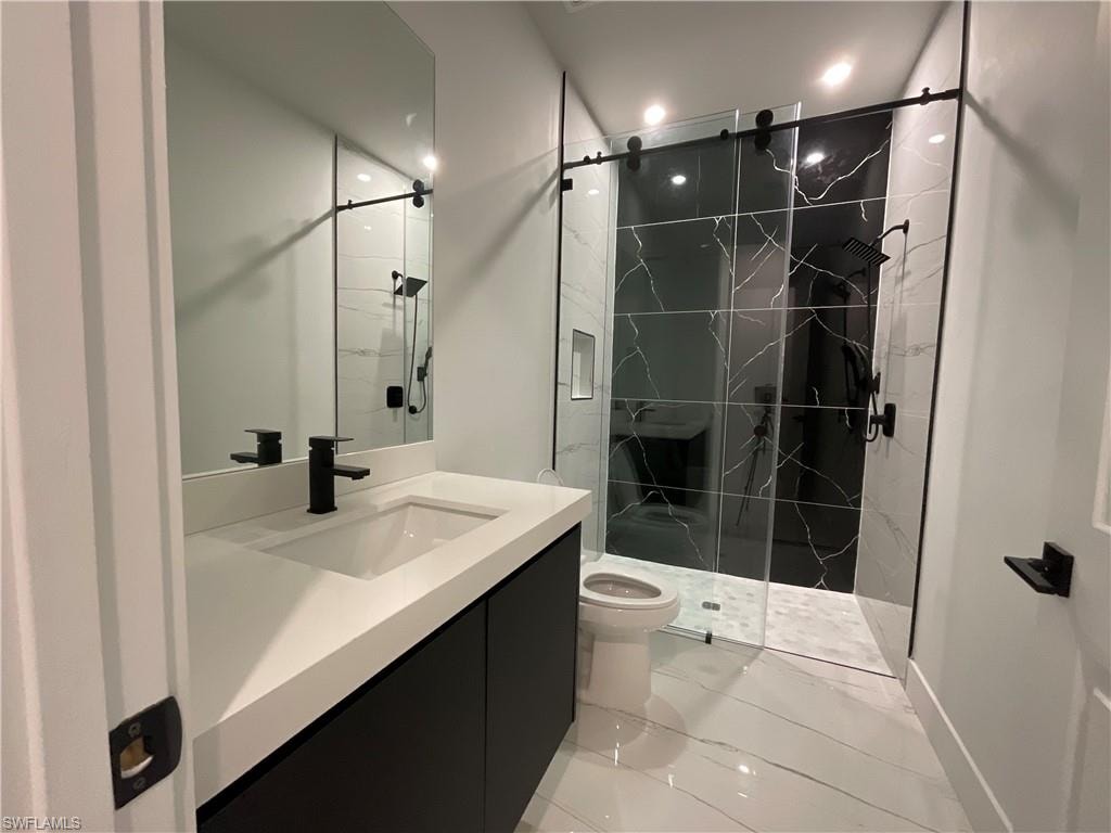Bathroom featuring a modern vanity with an integrated sink, matte black faucet, and a large mirror