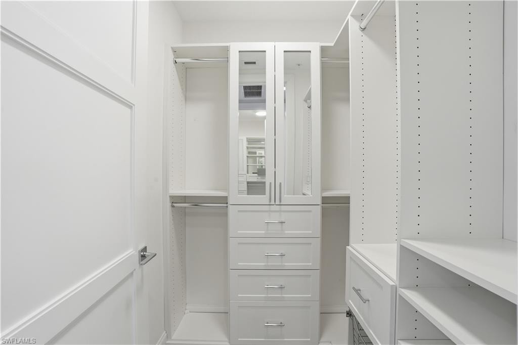 His and her closets with built in shelves and cabinetry.