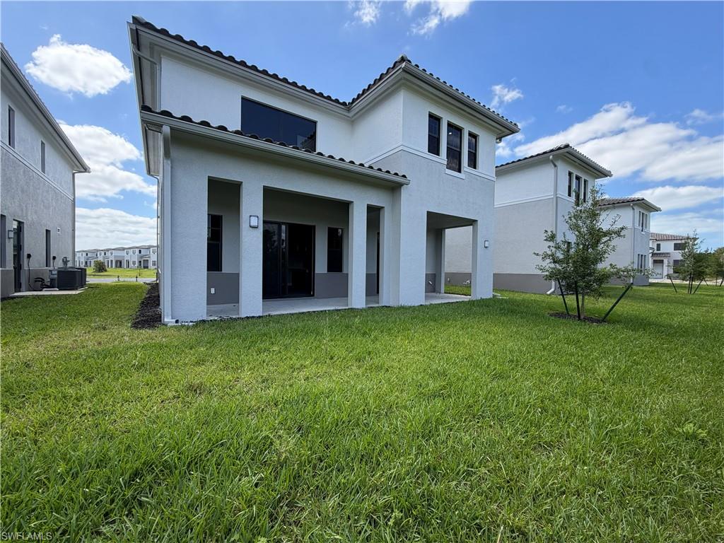 The property features a stucco exterior, a covered patio with recessed lighting, and a well-maintained lawn
