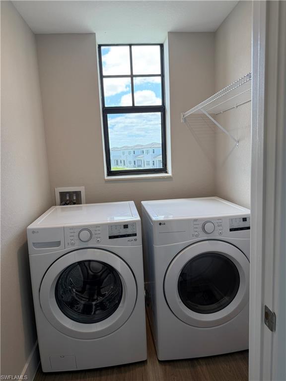 Dedicated laundry area featuring a window, overhead wire shelving, and wood-look flooring