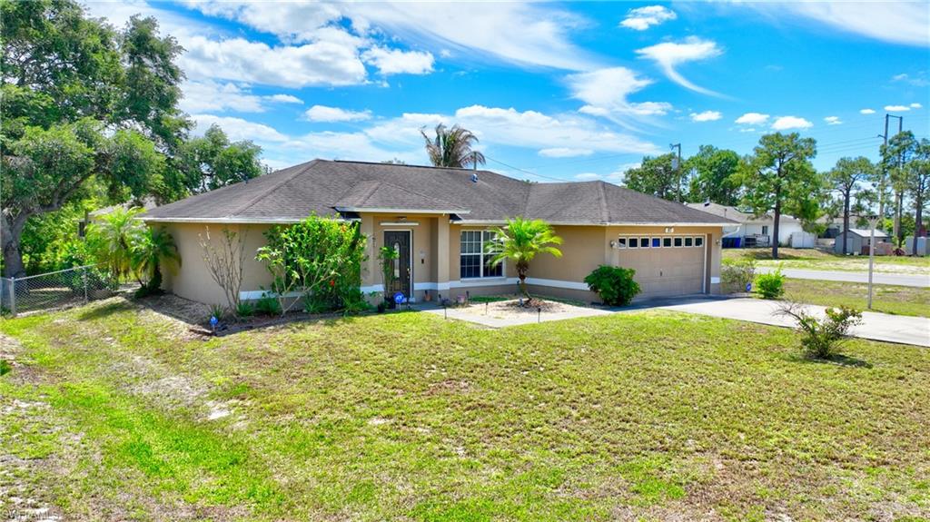 The property features a stucco exterior, a dark shingle roof, and an attached garage