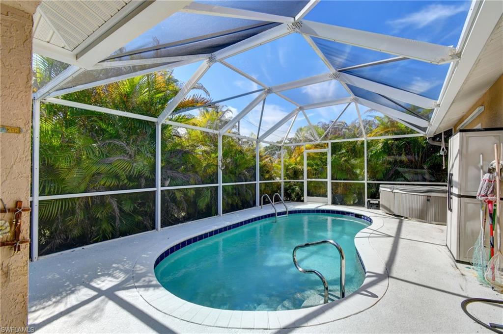 The property features a screened-in swimming pool with a hot tub and ample patio space for enjoyment
