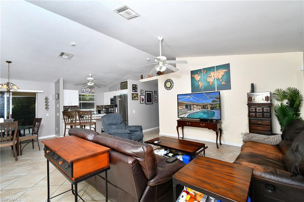 The open-concept living area features light-colored walls and tiled flooring
