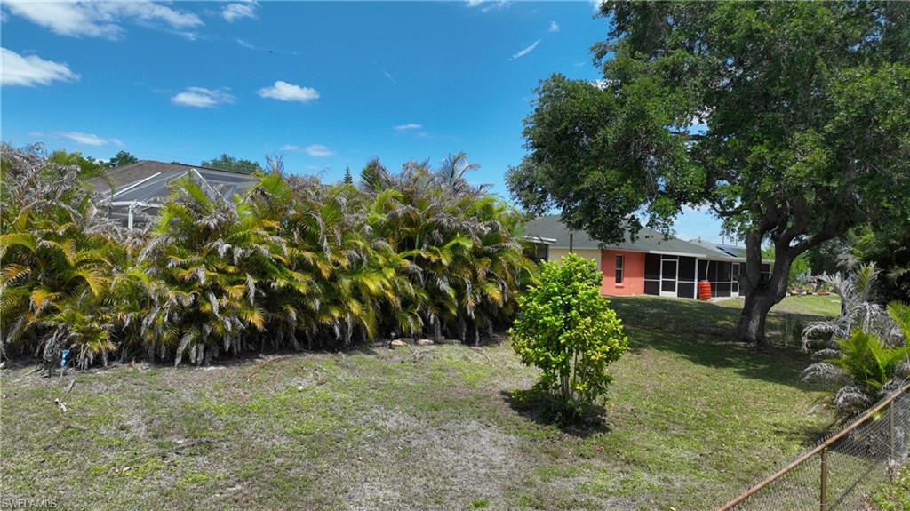 The property features an extensive lawn area with mature trees and vibrant green foliage