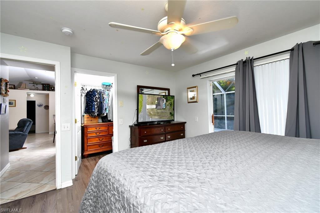 This room features a ceiling fan, a walk-in closet, and light-colored walls