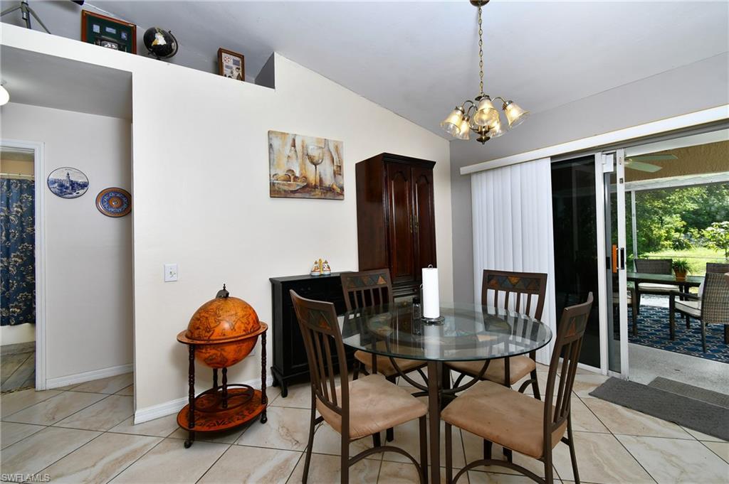 Dining area featuring tiled flooring, a decorative chandelier, and sliding glass doors leading to an outdoor screened patio
