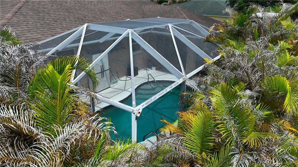 The property features an outdoor swimming pool enclosed by a screened cage structure