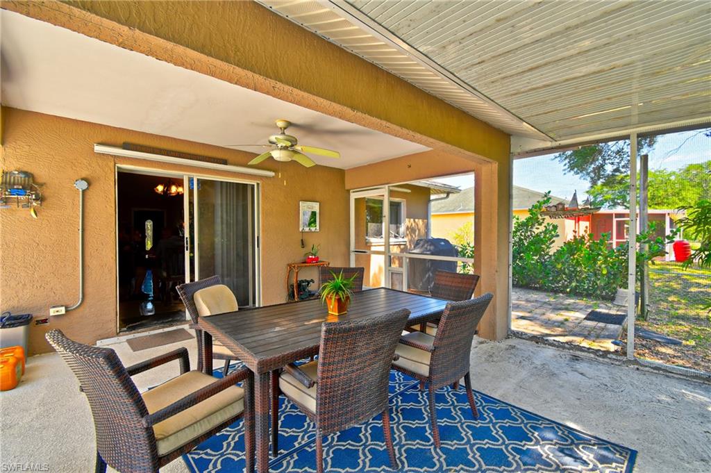 The screened-in patio features a ceiling fan, concrete flooring, and a sliding glass door leading to the interior