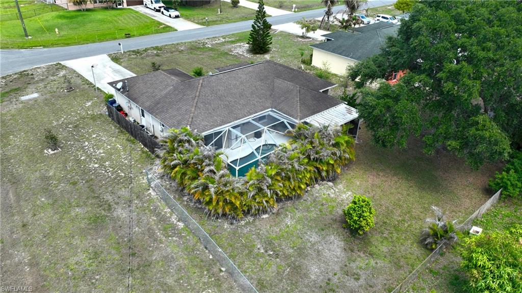 This property features a screened-in pool area, a paved driveway, and a well-maintained exterior