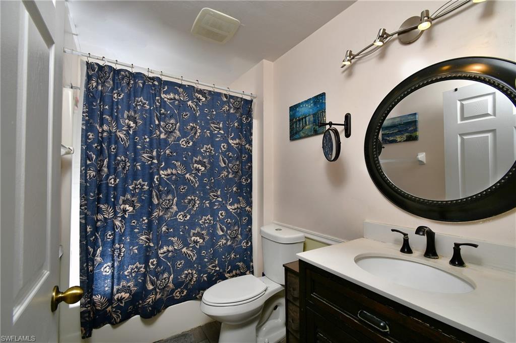 Bathroom featuring a vanity with a countertop, an oval mirror, and a track light fixture