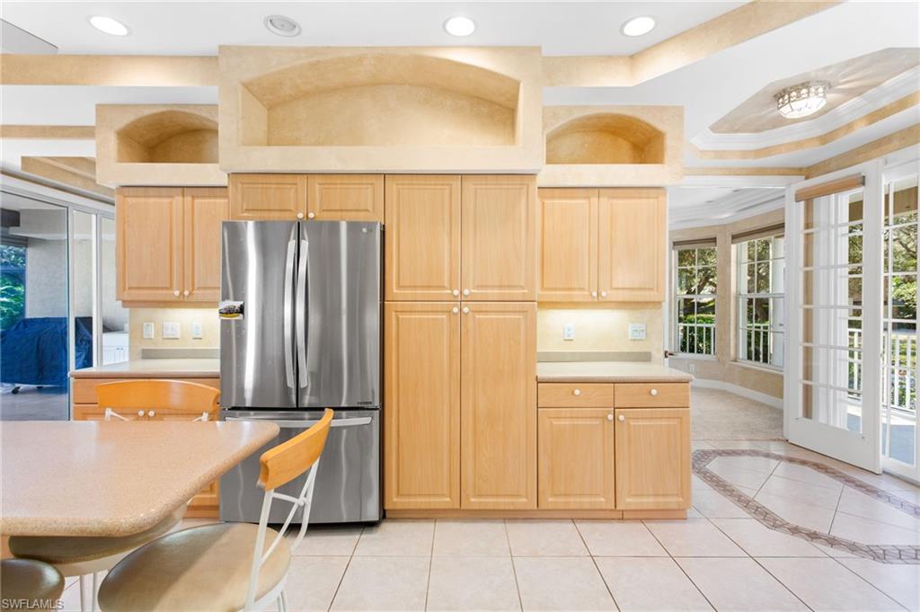 Kitchen featuring wood-finish cabinetry, stainless steel refrigerator, and recessed lighting