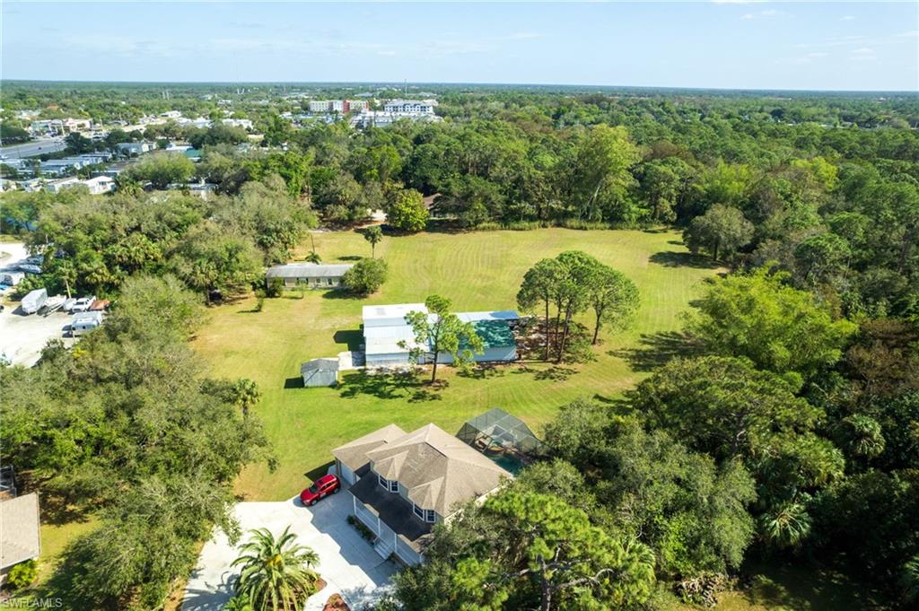 Expansive property featuring lush green lawns and abundant mature trees