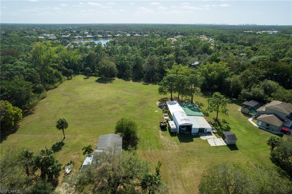 Expansive green spaces featuring mature trees and a detached structure with a metal roof