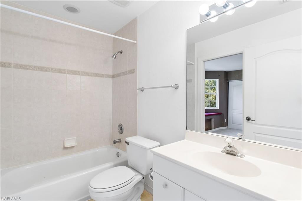 Bathroom featuring a white vanity with an integrated sink, polished chrome faucet, and overhead vanity lighting