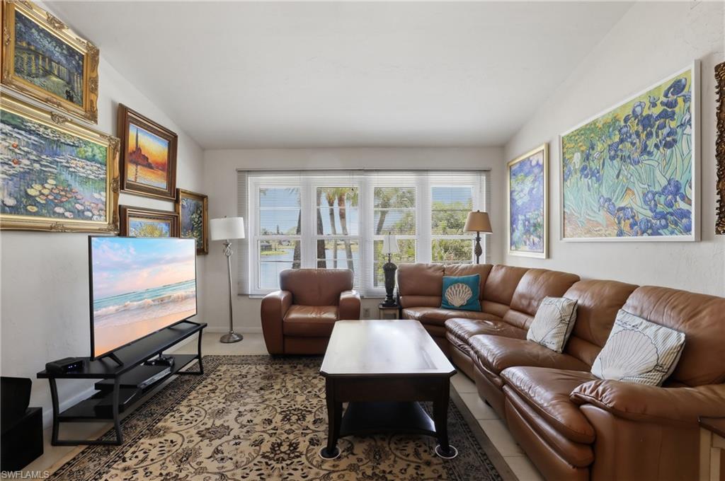 Living area featuring multiple pane windows, crown molding, and light-toned walls
