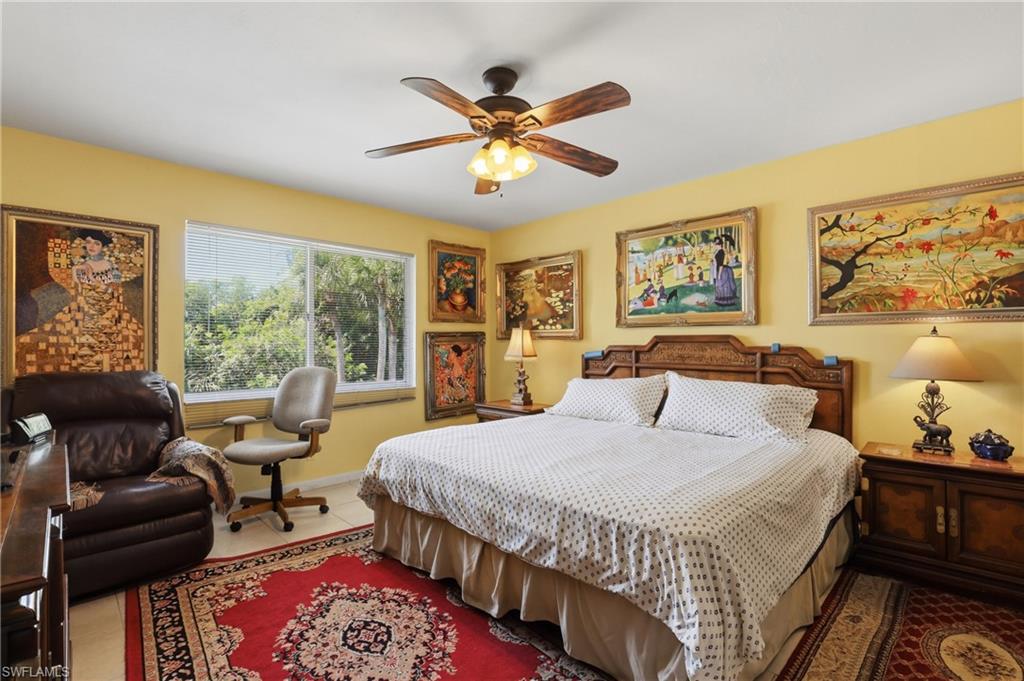 Spacious room featuring a multi-pane window, tile flooring, and a ceiling fan with integrated lighting