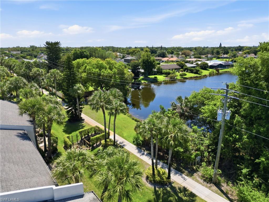 Expansive water frontage with mature trees and lush green landscaping