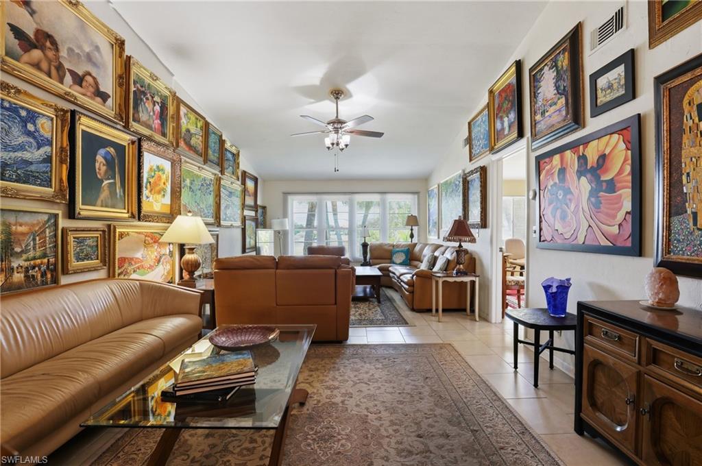 Open-concept living area featuring light-toned tile flooring, recessed lighting, and a ceiling fan