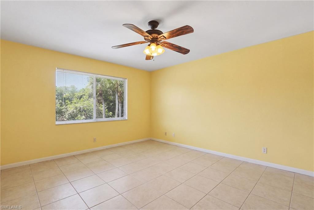 Spacious room featuring neutral tile flooring and a ceiling fan with integrated lighting