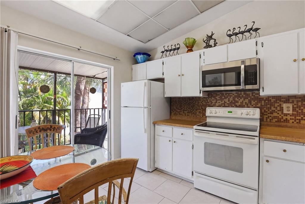 Kitchen featuring white cabinetry, wood-finish countertops, and an integrated stainless steel microwave