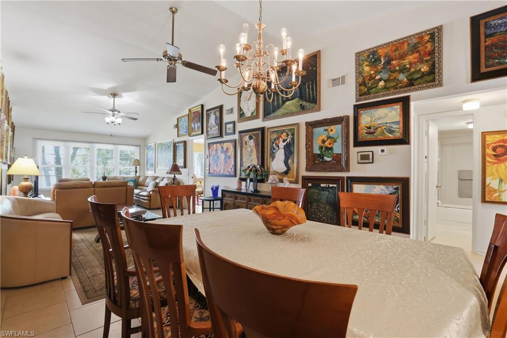 Open-concept dining area with vaulted ceilings and a brass-tone chandelier