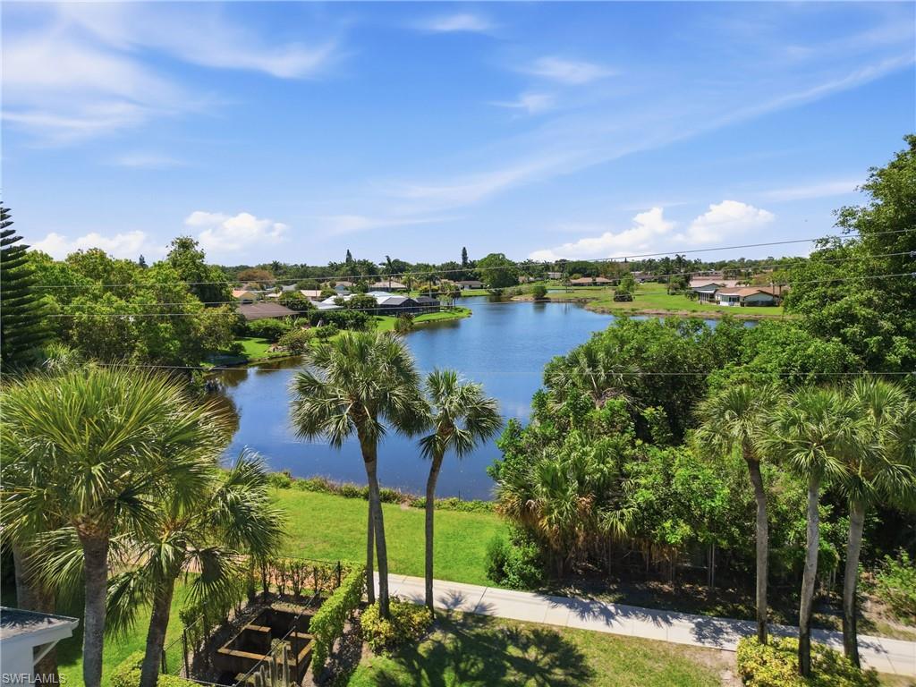 Expansive water feature bordered by lush green landscaping and mature palm trees