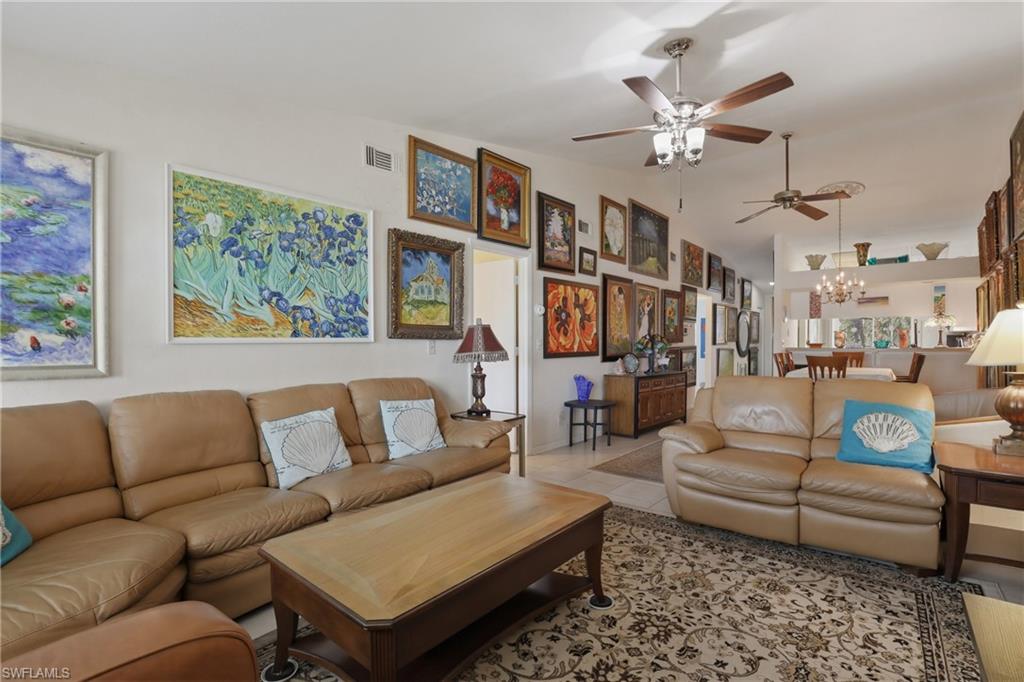 Open concept living area featuring light-toned walls and multiple ceiling fans