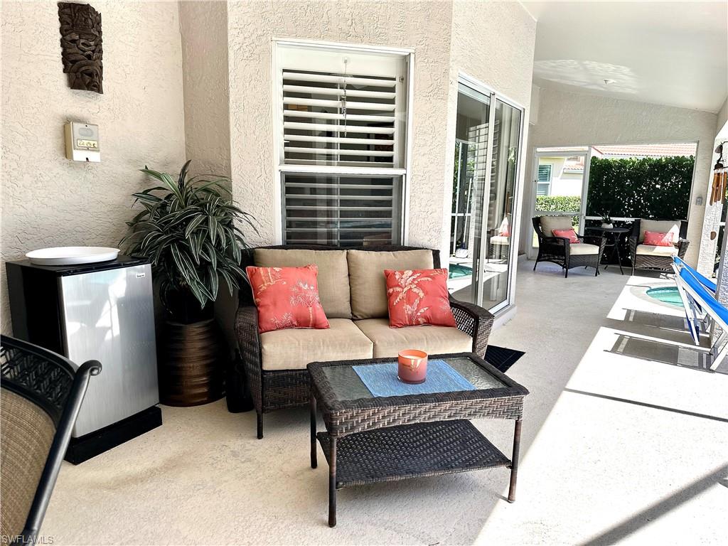 Just outside the kitchen and living room is a sofa, cocktail table, and beverage fridge, for outdoor relaxing and entertaining.