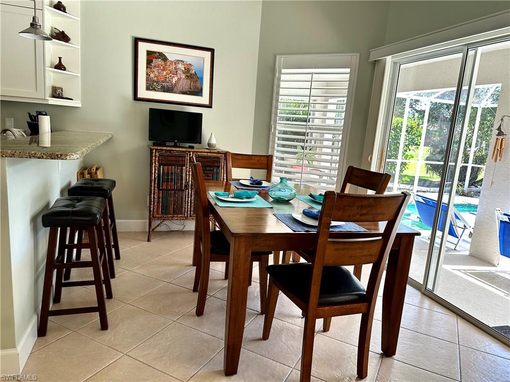 The kitchen includes a breakfast bar and a full size table for dining.