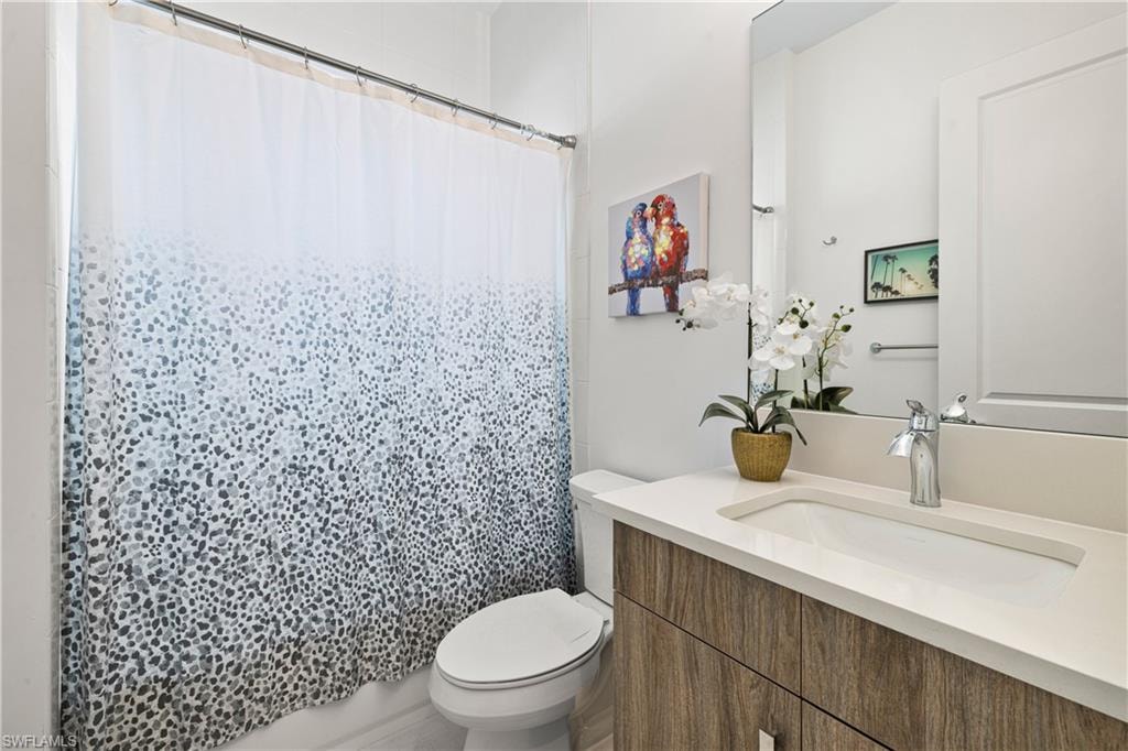 Bathroom featuring a quartz countertop vanity with an integrated sink, and a chrome faucet