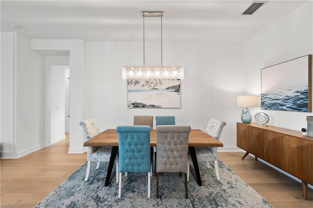 Bright dining area featuring wide wood flooring and a contemporary rectangular chandelier
