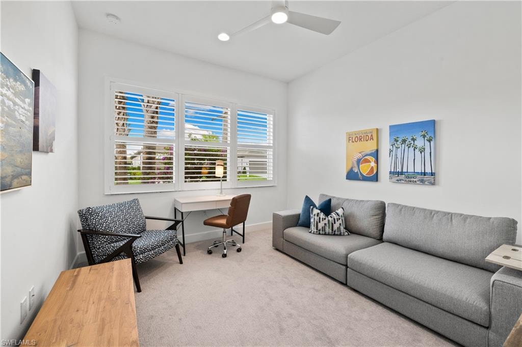 Large guest bedroom featuring a multi-pane window with white plantation shutters, a sleek ceiling fan, recessed lighting, and soft carpet flooring