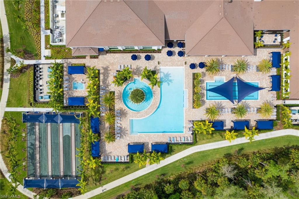 Resort-style amenities featuring multiple swimming pools, a circular water feature, shaded lounge areas, and bocce ball courts
