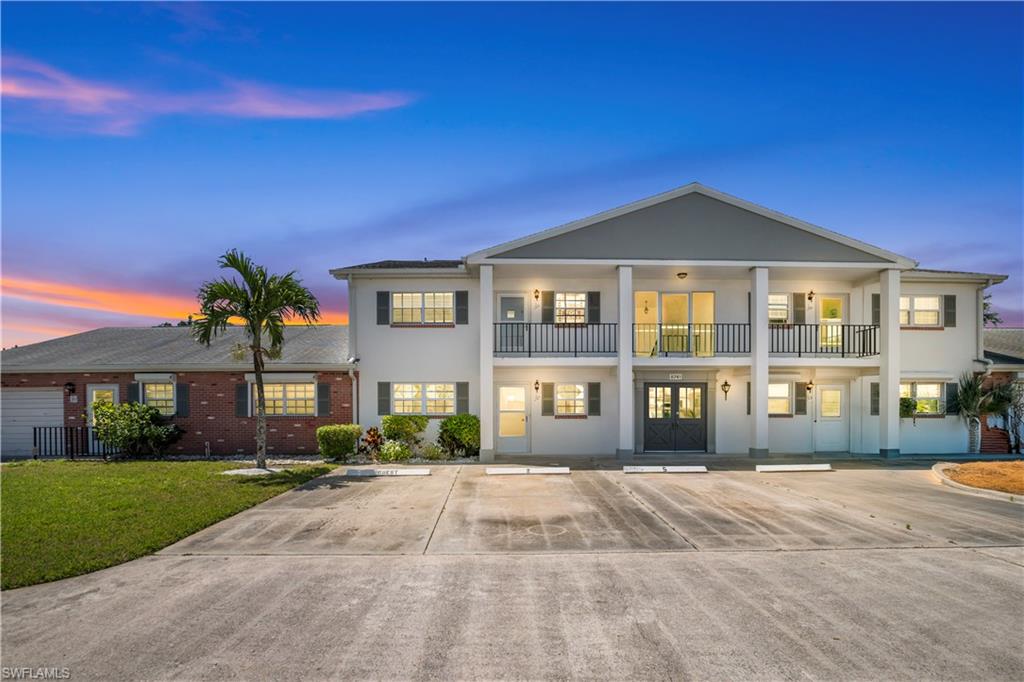 The property features a multi-story exterior with a gray and white facade, accented by dark window shutters