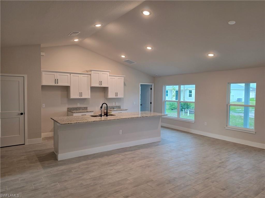 Open-concept living space with vaulted ceilings and recessed lighting