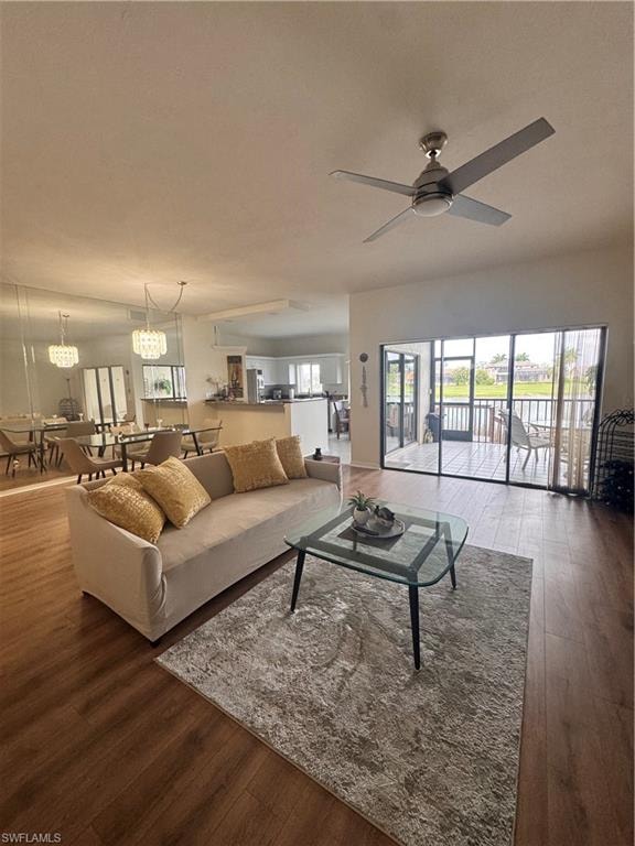Living area featuring hardwood flooring, a ceiling fan, and large sliding glass doors leading to an outdoor space