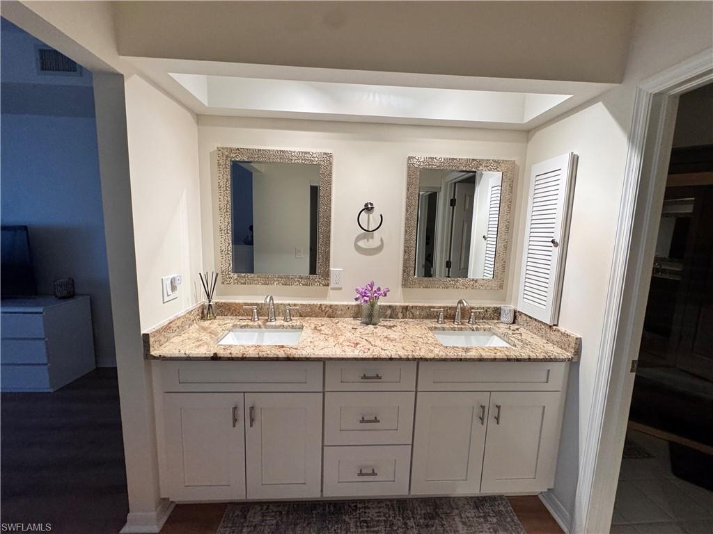 Dual vanity featuring a light-toned granite countertop, two undermount sinks, and chrome faucets