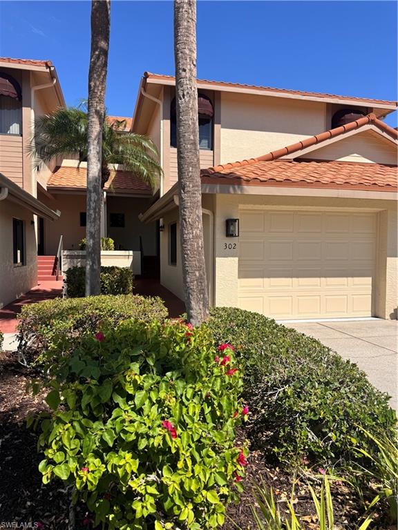 Exterior featuring a neutral stucco finish, orange tile roofing, and an attached garage with a number '302' address plaque