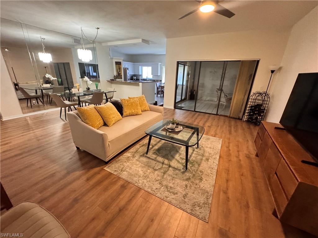 Spacious interior featuring wood-finish flooring, a ceiling fan, and sliding glass doors to the exterior
