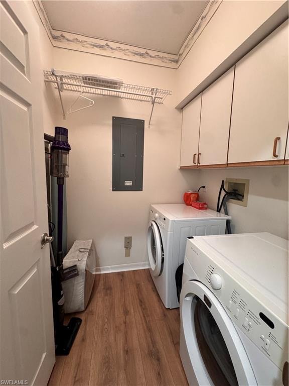 Dedicated laundry area featuring wood-finish flooring, overhead wire shelving, and built-in cabinetry with white doors and wood-tone handles