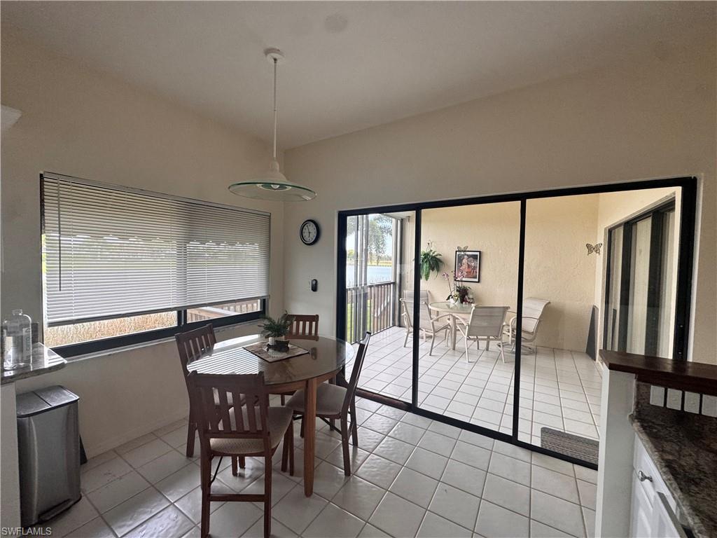 This dining area features tile flooring, a window with blinds, and a light fixture