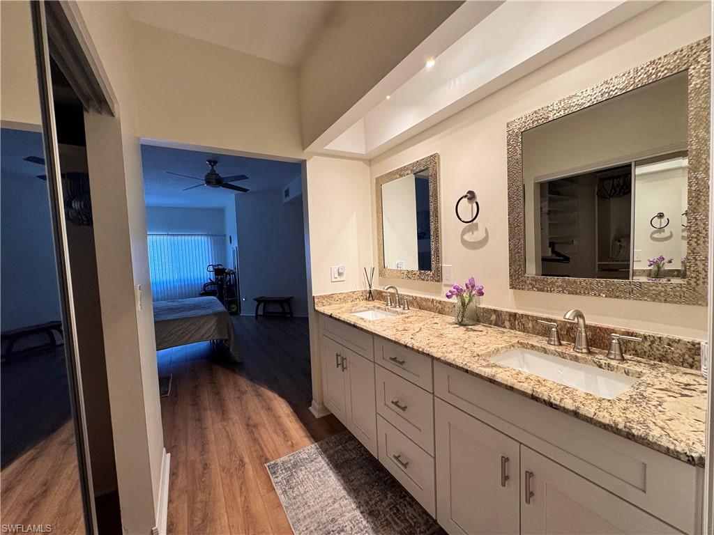Dual vanity with a stone countertop, under-mount sinks, and framed mirrors