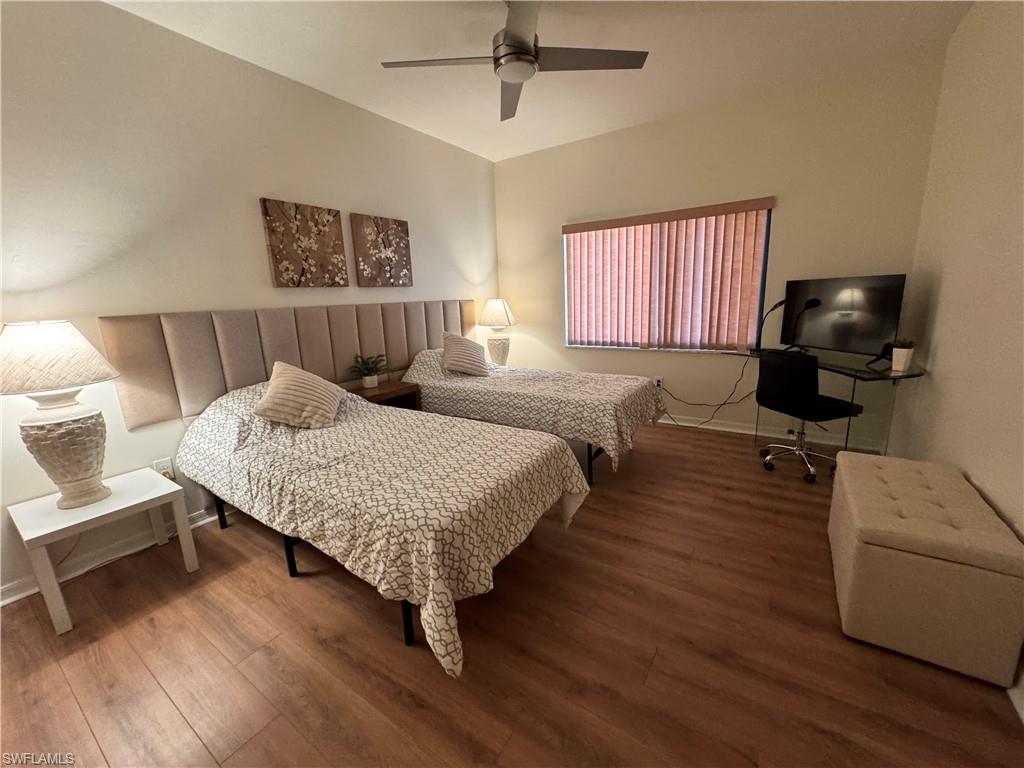 Bedroom featuring wood-finish flooring, a contemporary ceiling fan, and a window with blinds