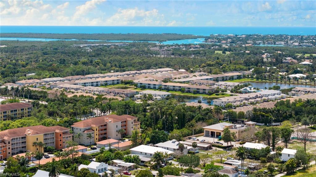 Expansive aerial perspective showcasing a coastal community with multiple residential buildings