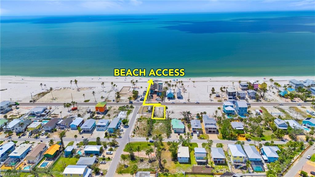 Birds eye view of property featuring a water view, a residential view, and a view of the beach  - Virtually Edited Image