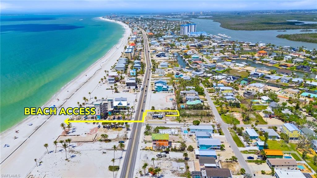 Birds eye view of property with a beach view and a water view  - Virtually Edited Image