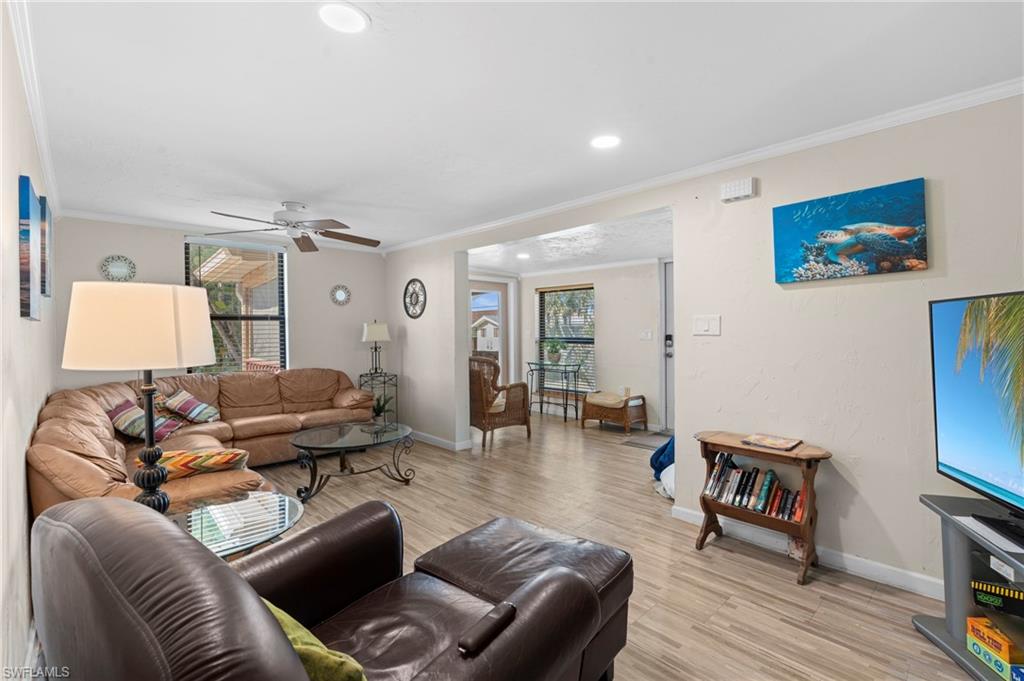 Living room featuring comfortable seating and an open layout that flows seamlessly into the dining area  - Virtually Edited Image