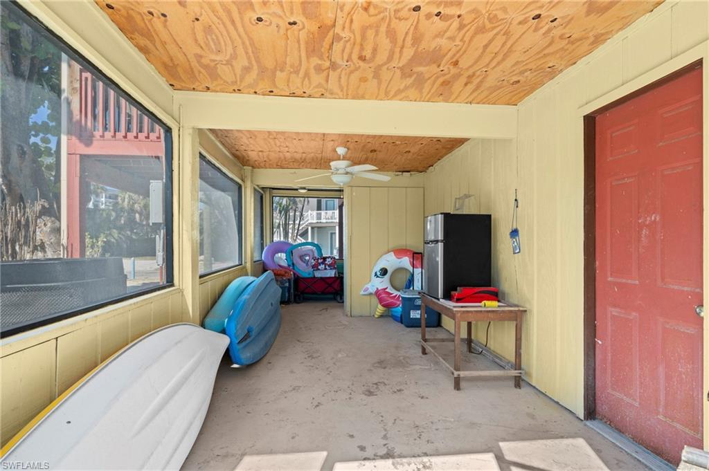 Screened-in storage or utility area, ideal for stashing beach gear, kayaks, and outdoor essentials  - Virtually Edited Image